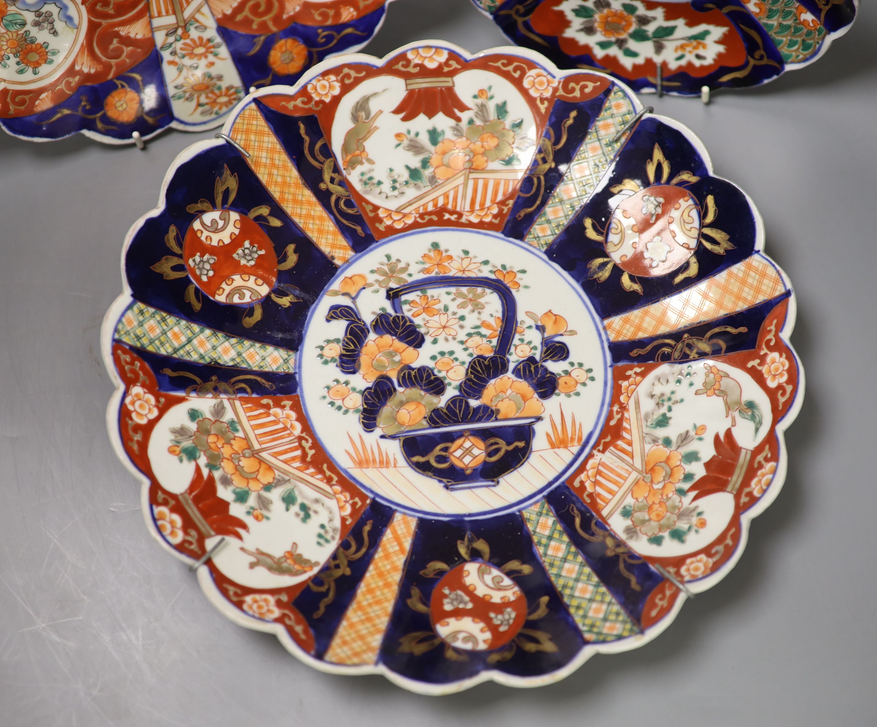 A pair of Meiji period Imari petal rimmed dishes and one other smaller dish, largest diameter 33cm